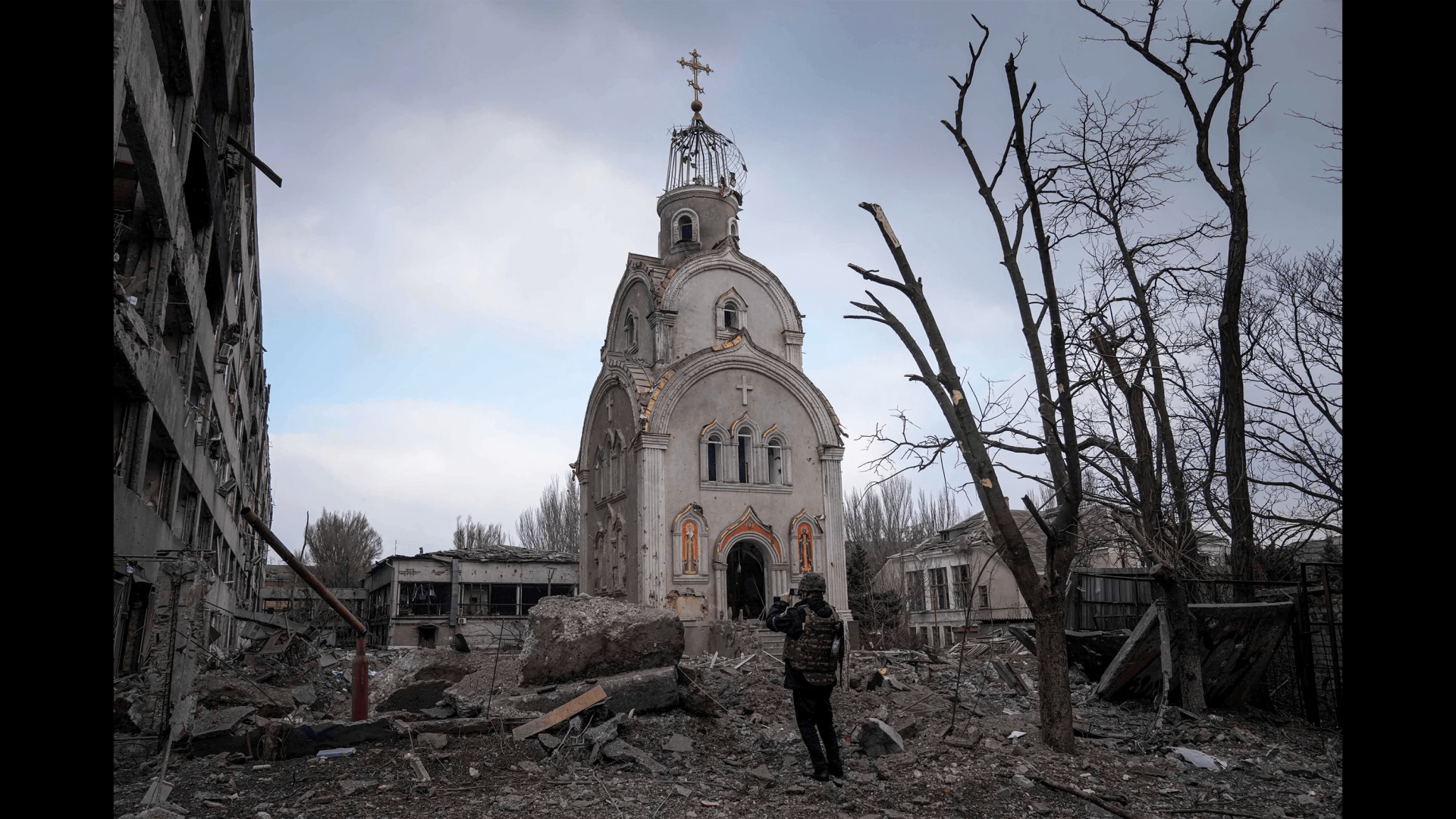 Seorang tentara Ukraina memotret sebuah gereja yang rusak setelah penembakan di distrik perumahan di Mariupol, Ukraina, pada 10 Maret.