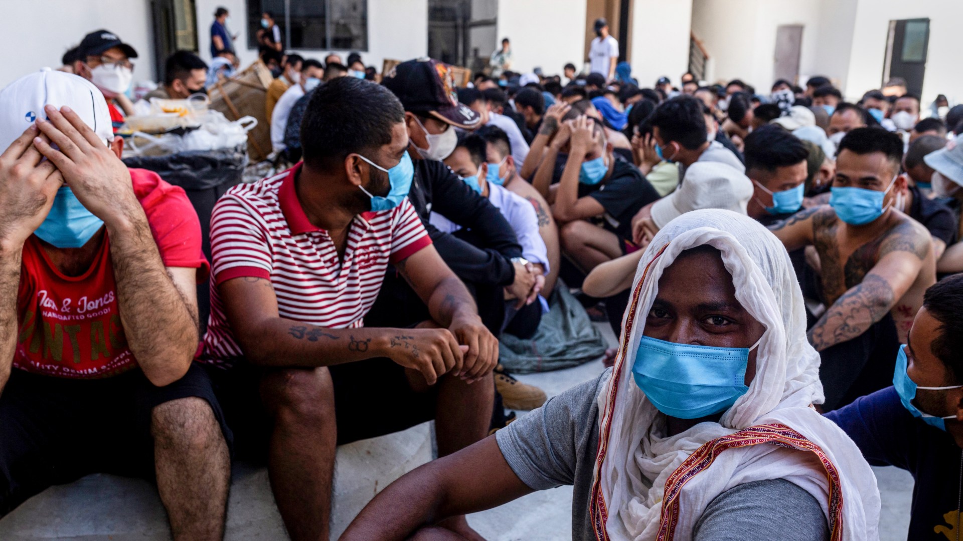 Scam center victims sit on the ground during a crackdown operation by the Karen Border Guard Force (BGF) in Myanmar.