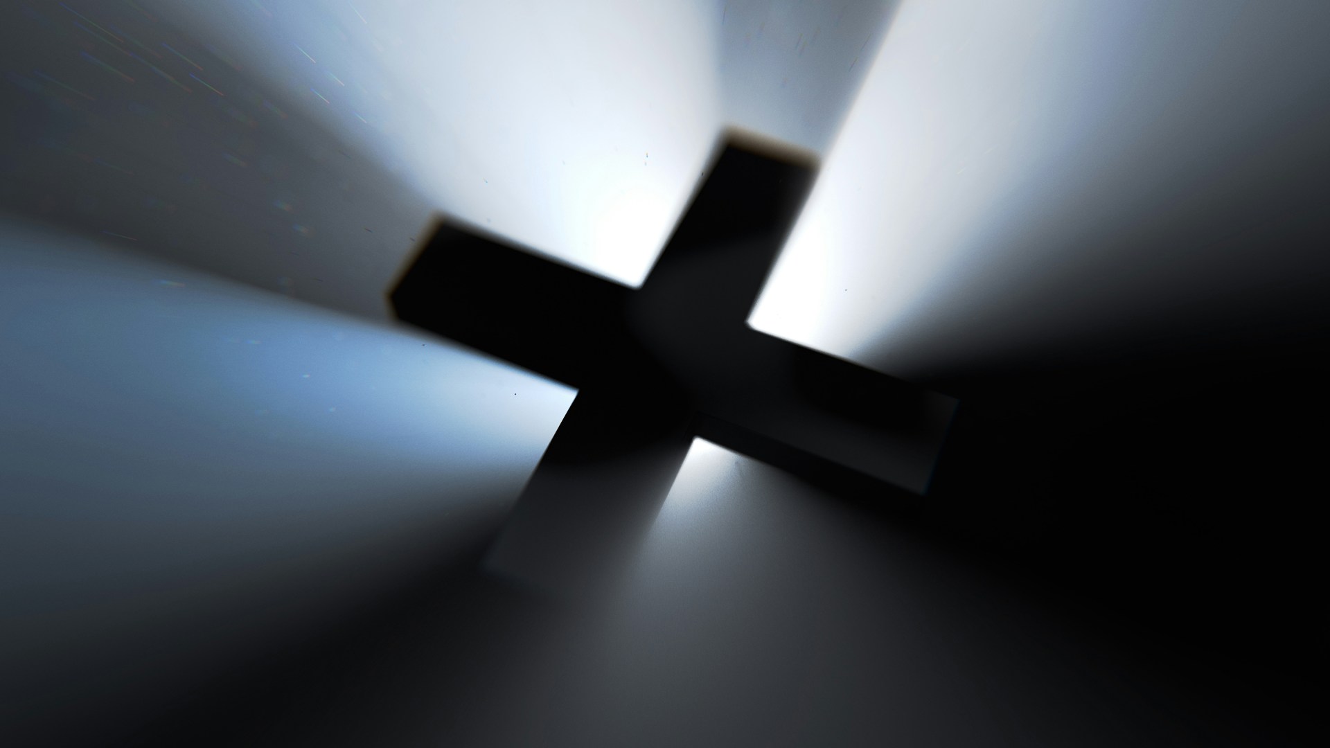 A cross with a light illuminating it from behind in the dark